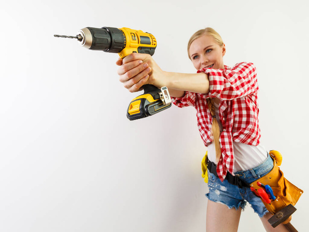 Woman using drill on wall - Фото, зображення