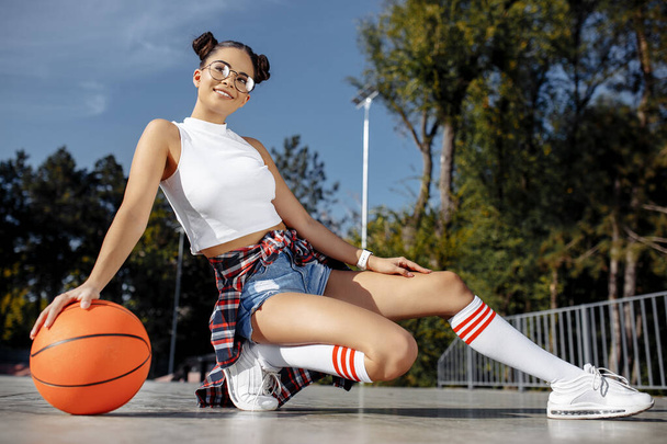 Charming brunette young woman possing with basket ball at the skatepark. Freedom concept. - Foto, immagini