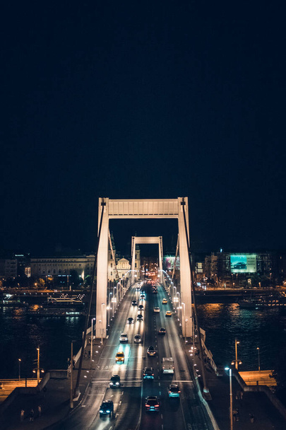 Éjszakai forgalom az Erzsébet hídon. Átkel a Dunán, és összekapcsolja Budát és Pestet. Budapest, Magyarország. - Fotó, kép
