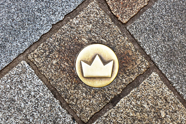 Вид сверху на коронный маркер брасса на мощеных брусчаткой улицах, который показывает место коронации, Братислава, Словакия. Старый город
 - Фото, изображение