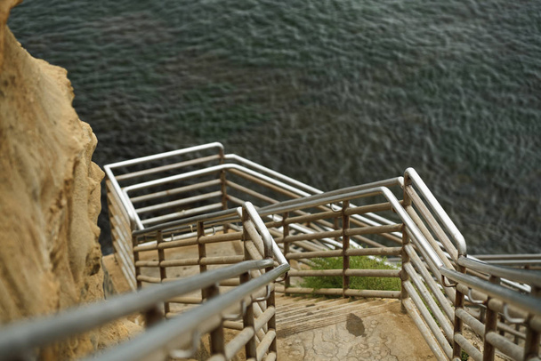 Tengerparti lépcső a Sunset Cliff Természeti Parkban, San Diegóban. Nagyszerű hely látni az óceán hullámait és erejét. - Fotó, kép