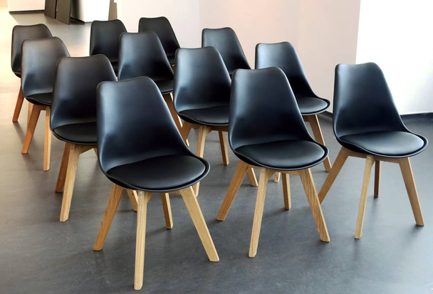 Minimalist Scandinavian design of conference room. Rows of black chairs in meeting room. Seats for participants - 写真・画像