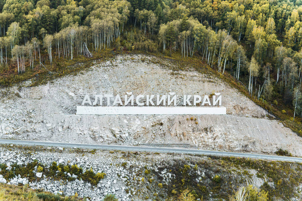 Inscriptie in het Russisch Altai Krai is de naam van een regio in West-Siberië in Rusland. Brieven op een rots in de buurt van de slangenweg. stad Belokurikha 2 - Foto, afbeelding