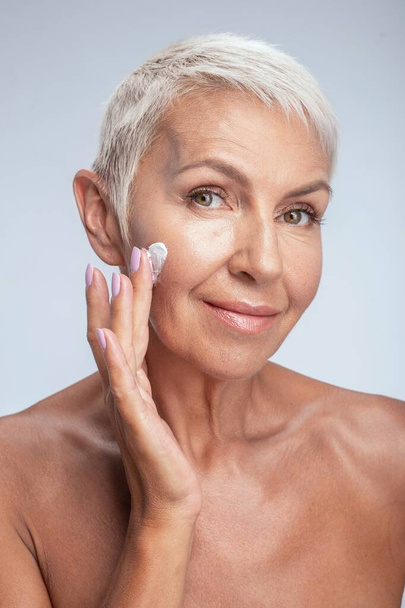 Beautiful aged female person testing new cream - Fotoğraf, Görsel