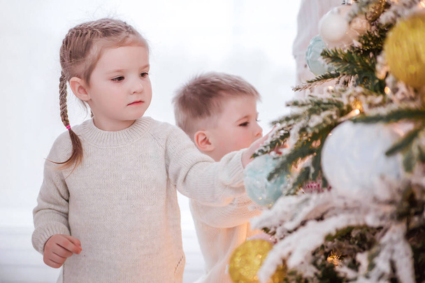 Kislány segít díszíteni a karácsonyfát - Fotó, kép