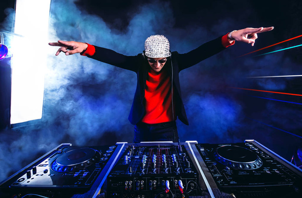Glamoureuze DJ speelt op de draaitafel in de nachtclub. Club, nachtleven.  - Foto, afbeelding