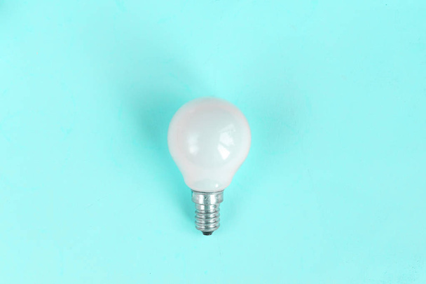 White light bulb isolated on mint green color background with space for text - Photo, Image