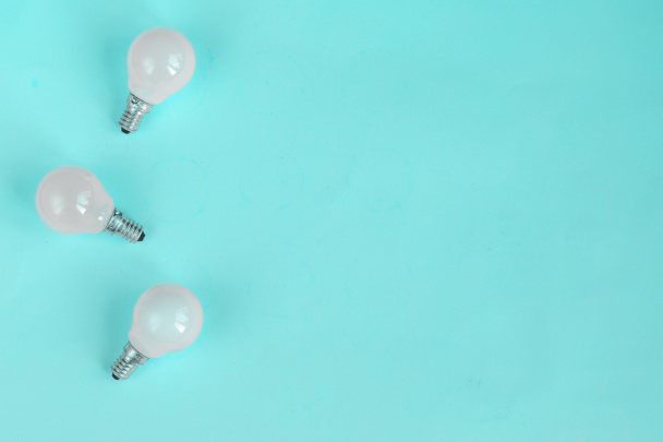 White light bulb isolated on mint green color background with space for text - Photo, Image