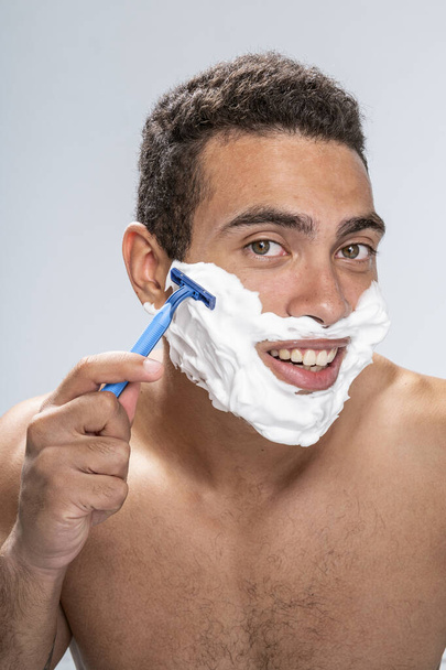 Handsome man beginning to shave his face - Фото, зображення