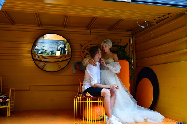 Joyeux jeune couple de mariage baisers et câlins dans la chambre jaune
 - Photo, image