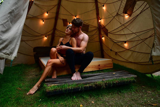 lány és srác játszik az ágyon egy sátorban koszorúkkal a romantika - Fotó, kép
