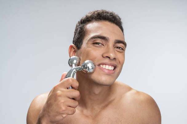 Hombre feliz disfrutando de su masaje facial matutino
 - Foto, Imagen