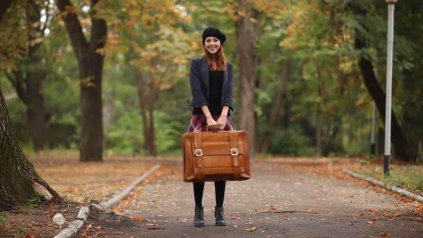 κοκκινομάλλα κοπέλα με βαλίτσα σε εξωτερικούς χώρους - Πλάνα, βίντεο