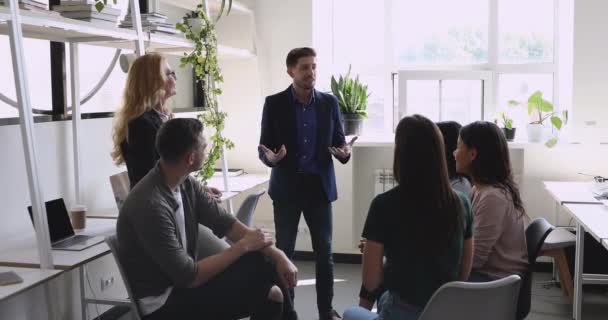 Confident male leader speaking to diverse friendly team in office - Séquence, vidéo