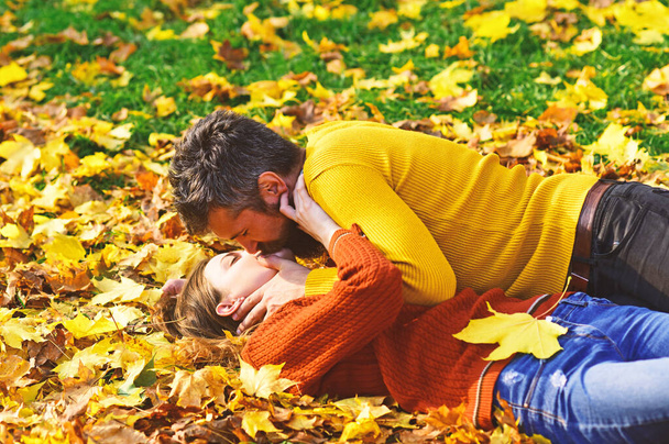 Man and woman with romantic faces on grass and leaves - Foto, imagen