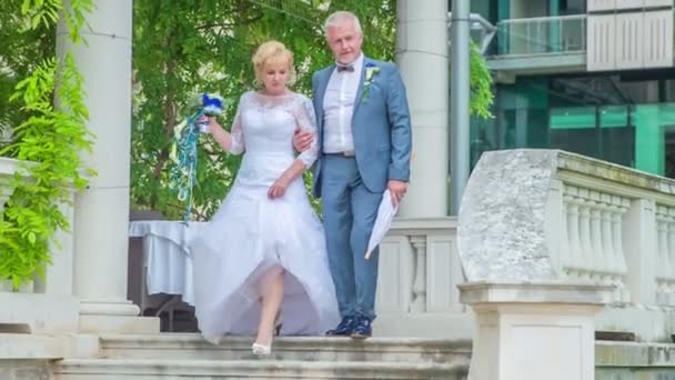 Ένα παντρεμένο ζευγάρι κατεβαίνει τις σκάλες και κάνουν φωτογράφηση μετά την τελετή του γάμου.. - Πλάνα, βίντεο