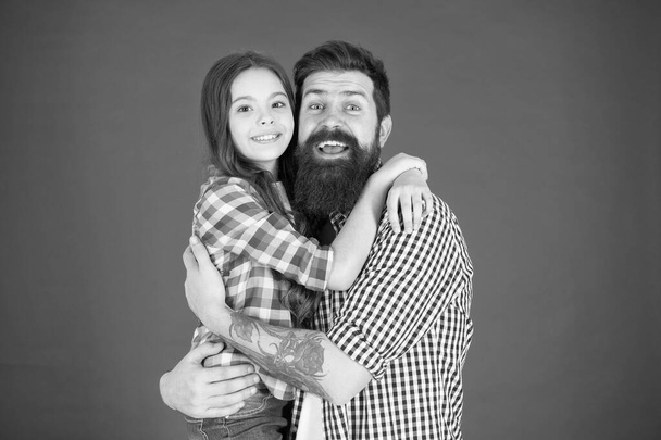 Sweet hug. Man bearded father and cute little girl daughter on red background. Celebrate fathers day. Family values concept. Family bonds. Friendly relations. Father hipster and his daughter - Fotografie, Obrázek