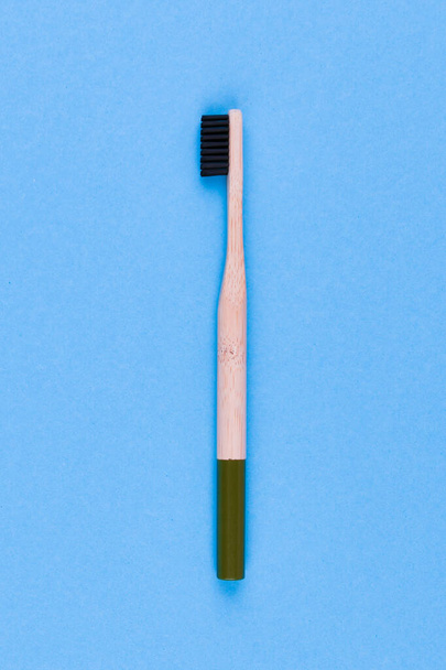 青い背景の木の歯ブラシ青い背景に木製の歯ブラシを閉じます。エコブラシ. - 写真・画像