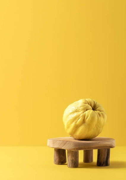 Quince fruit on tiny wooden table. Yellow autumn fruits - 写真・画像