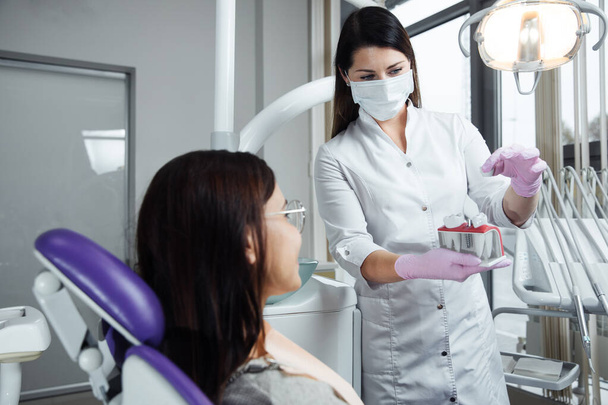 Een vrouw bereidt zich voor op een tandheelkundig onderzoek. Vrouw met tanden onderzocht bij tandartsen.  - Foto, afbeelding