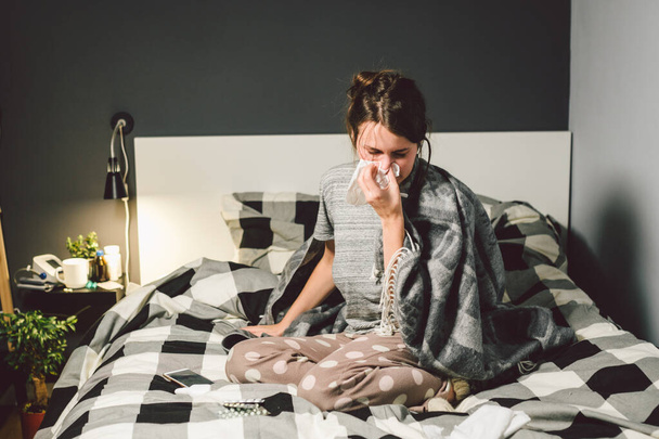 sick woman with runny nose, sitting in bed. woman feeling unwell and sneeze bedroom. Woman holding tissue ,flu symptoms. Healthcare medical concept. Cold And Flu Season. woman with allergy symptoms - Fotografie, Obrázek
