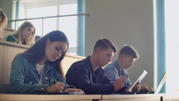 Πανεπιστημιακή παραγωγή ένα μεγάλο ακροατήριο, φοιτητές γράφουν στα σημειωματάρια διάλεξη και φορητούς υπολογιστές - Πλάνα, βίντεο