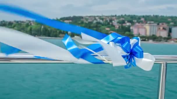 Un beau bleu et blanc bat dans le vent sur un yacht. C'est une belle journée d'été et un couple se marie
. - Séquence, vidéo