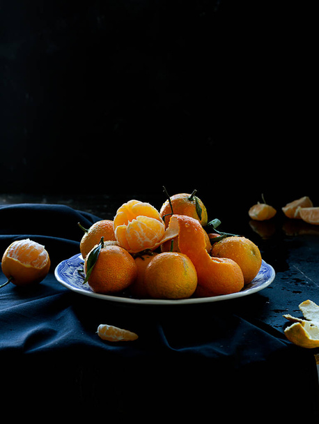 Fresh spanish mandarin oranges fruit with leaves on rustic table, dark and moody style - Fotoğraf, Görsel