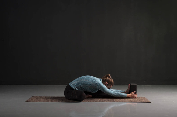 Donna che fa yoga training, seduta a Janu Sirsasana
 - Foto, immagini