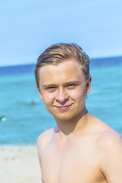 Handsome confident teenager at the beach with wet hair after swi - Foto, immagini
