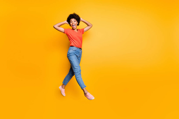 Full length photo of funny funky crazy girl have walk jump go feel cheerful have weekends free time in spring wear red stylish clothes sneakers isolated over yellow color background - Fotografie, Obrázek