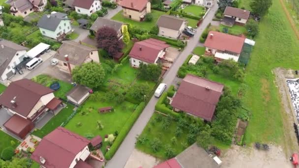 A white van is driving through a village. Aerial shot. It's summer time and everything is green. - Footage, Video