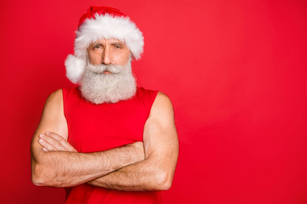 Portrait of confident snat claus ready to workout real coach looking with his arms crossed wearing trendy sports wear santa cap isolated over red background - Fotografie, Obrázek
