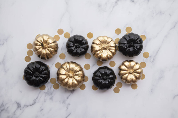 Luxury gold and black autumn pumpkin flat lay composition on a marble background - 写真・画像