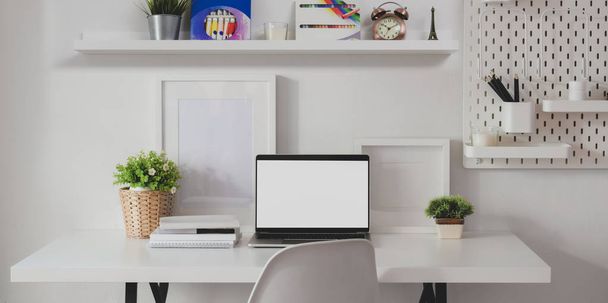 Minimal home-office room with open blank screen laptop computer with decorations and office supplies  - Photo, Image