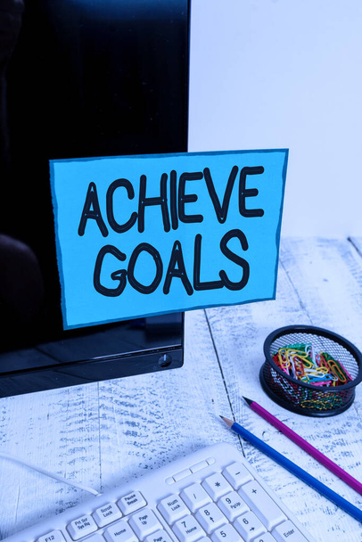 Conceptual hand writing showing Achieve Goals. Business photo text Results oriented Reach Target Effective Planning Succeed Note paper taped to black screen near keyboard stationary. - Photo, Image