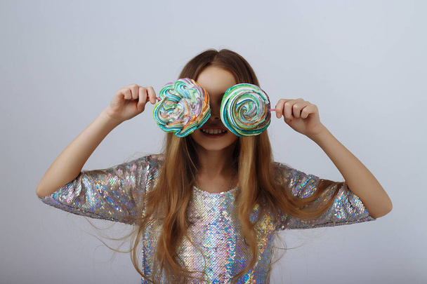 beautiful girl smiles and holds a lolly in her hands. a marshmallow long blond hair. - Foto, Imagen