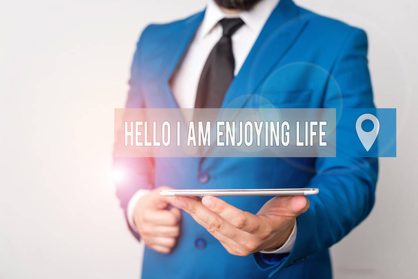 Writing note showing Hello I Am Enjoying Life. Business photo showcasing Happy relaxed lifestyle Enjoy simple things Businessman in blue suite with a tie holds lap top in hands. - Photo, Image