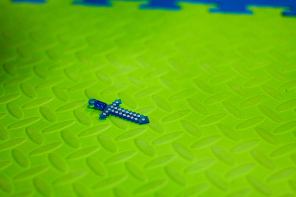 Minecraft játék kard zöld háttérrel. másolás tér, felülnézet, lapos laikus, háttér üres hely szöveg - Fotó, kép