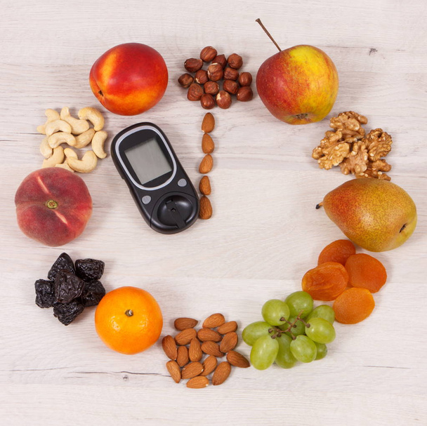 Γλυκόμετρο για τον έλεγχο του επιπέδου της ζάχαρης και ρολόι από φρούτα, ώρα για ψηφίσματα της έννοιας της υγιεινής διατροφής - Φωτογραφία, εικόνα