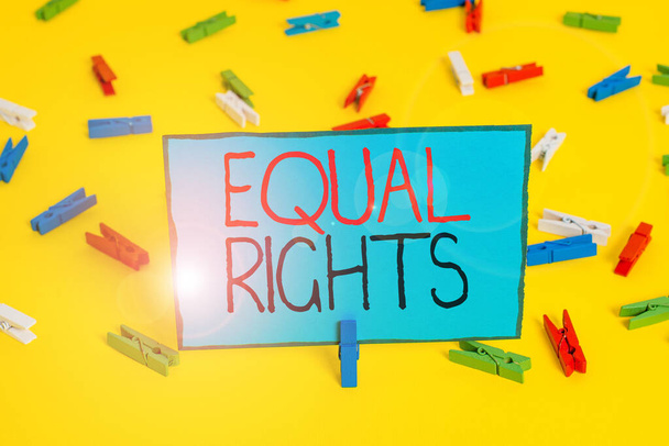 Egyenlő jogokat mutató szöveges jel. Fogalmi fotó Egyenlőség a törvény előtt, amikor minden bemutató azonos jogok Színes ruhacsap papírok üres emlékeztető sárga padló háttér iroda. - Fotó, kép