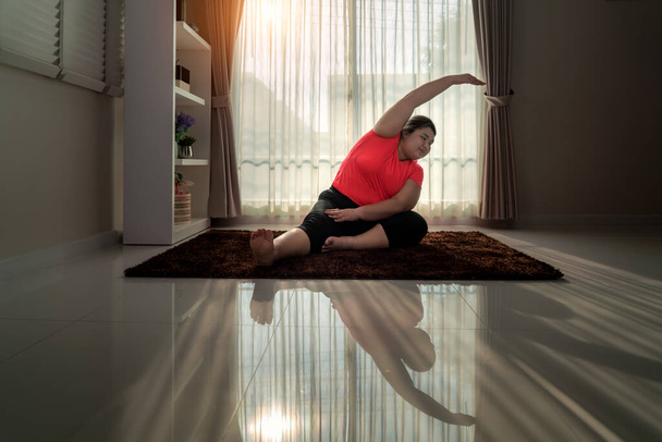 Asian Overweight woman exercising yoga Seated side bend pose alo - Photo, Image