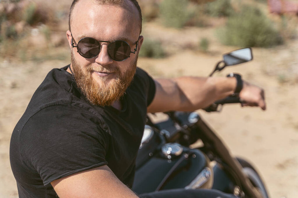 Close up of a handsome bearded man sitting on bike - Foto, immagini