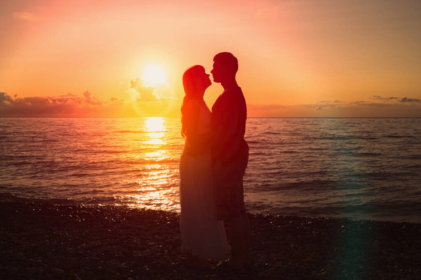 Dois jovens amantes de pé em uma praia e olhando um para o outro
 - Foto, Imagem