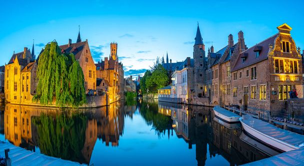 Bruges, Belçika 'nın Bruges şehrinde geceleri eski binalarla gökdelenler çiziyor. - Fotoğraf, Görsel