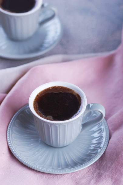 Café negro en una taza pequeña con un platillo
 - Foto, imagen