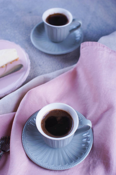 Tarta de queso y café negro y una taza pequeña
 - Foto, imagen