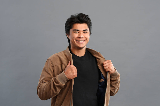 Portrait of handsome Asian man on grey background - Фото, зображення