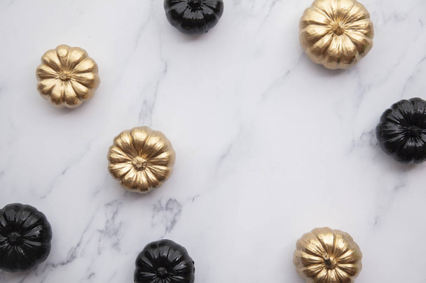 Luxury gold and black autumn pumpkin flat lay composition on a marble background - Photo, image