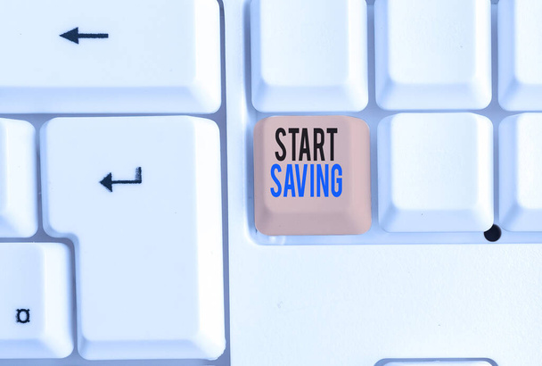 Handwriting text Start Saving. Concept meaning money that a demonstrating keeps in an account in a bank or like White pc keyboard with empty note paper above white background key copy space. - Photo, Image